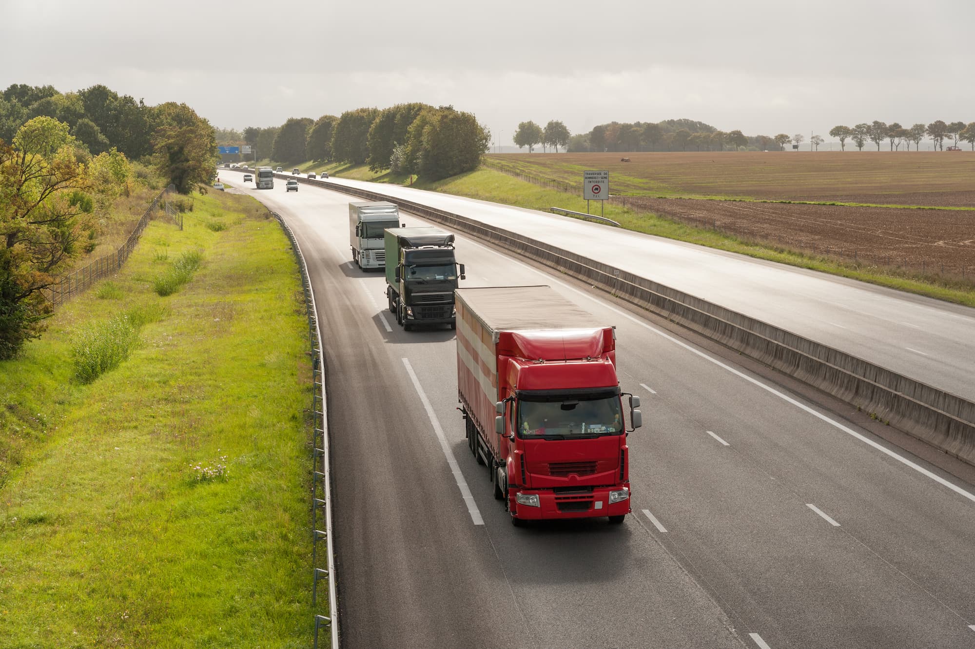 3 camions en ligne sur une autoroute